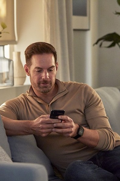 somfy-man-on-a-sofa-using-smartphone-in-living-room